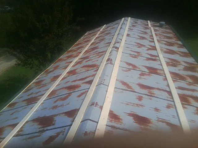 Rusted metal roof panels with new wood purlins before replacement — Storm Damage Roof Repair in Claridge by Roofing Brothers