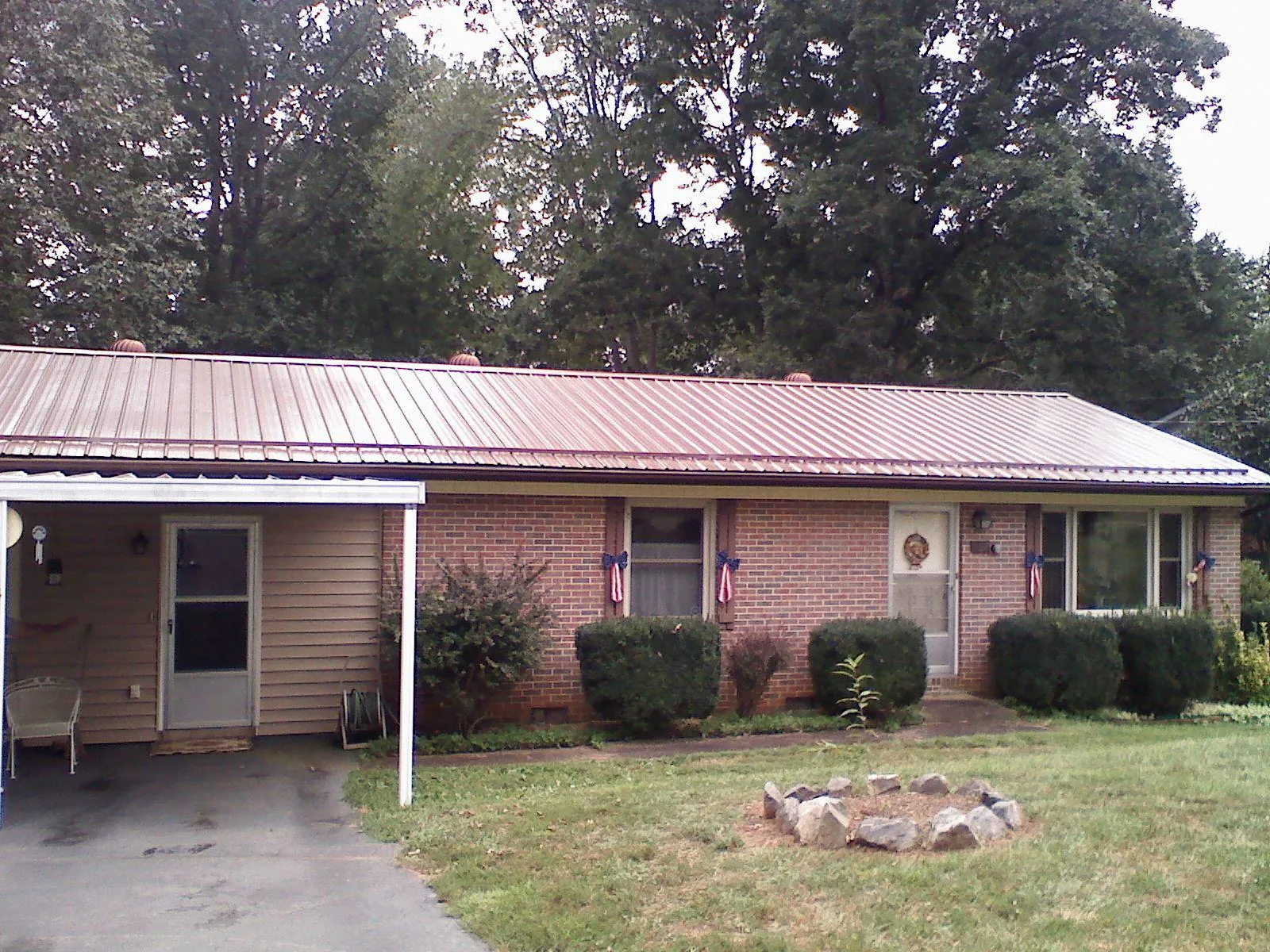 Bronze metal roof and carport on a brick ranch home — Roof Repair work by our crew in Claridge